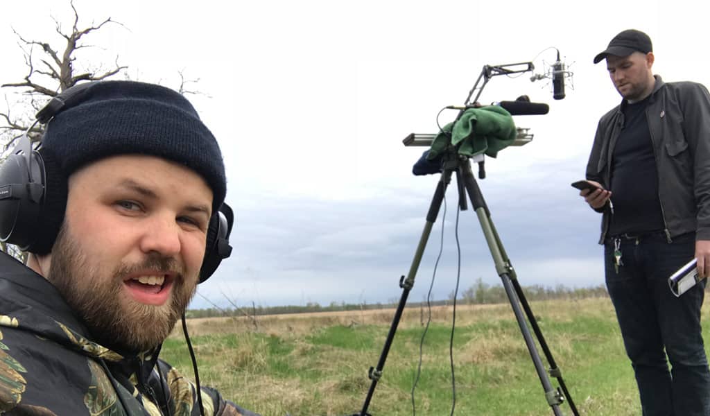 Two men recording complex noise in a forest